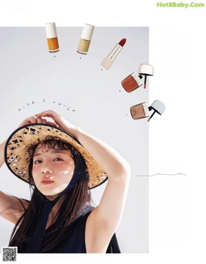 A woman wearing a straw hat and a black top.
