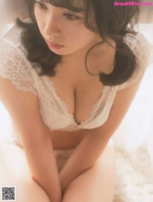 A woman in a white towel standing in front of a mirror.