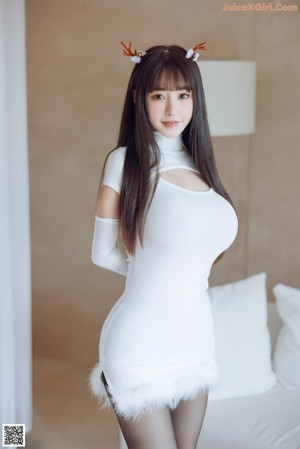 A woman sitting on a white couch wearing black stockings.
