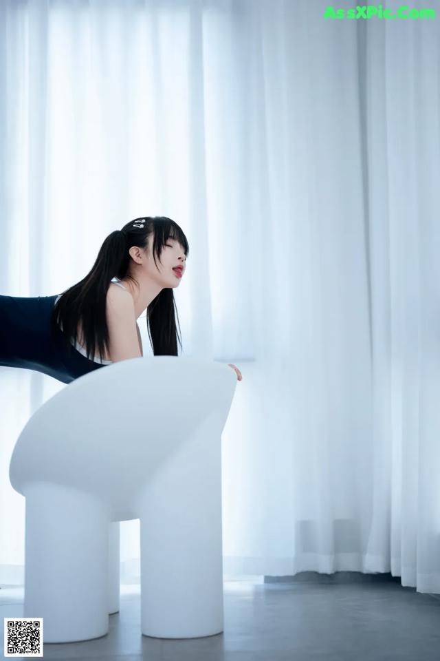 A woman sitting on top of a white chair.