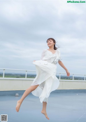 A woman in a white dress posing for a picture.