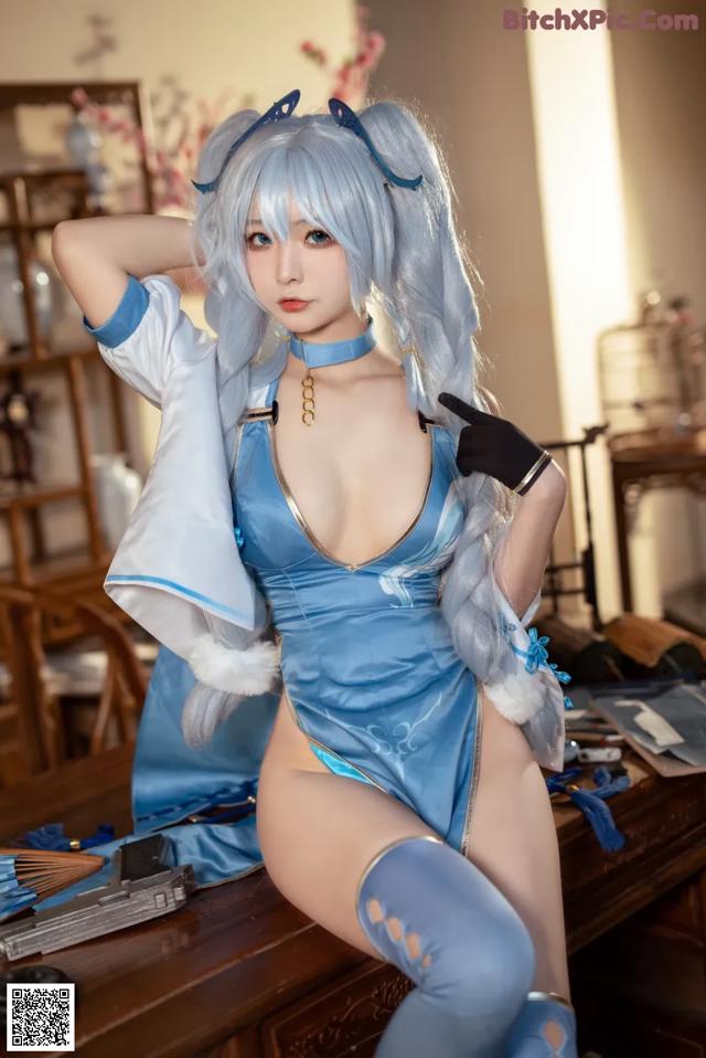 A woman in a blue and white outfit posing for a picture.
