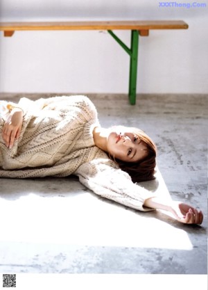 A woman laying on the ground with her legs crossed.