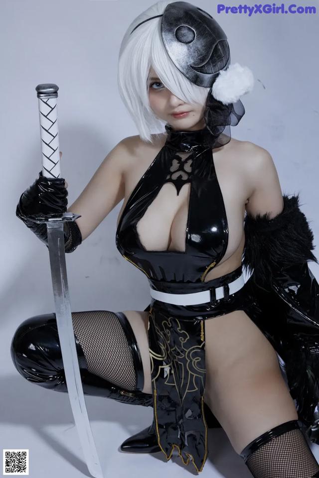 A woman in a black and white outfit holding a sword.