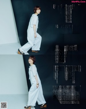 A woman in a white shirt leaning against a wall.