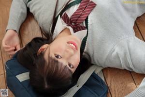 A young woman in a school uniform posing for a picture.