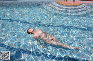 A woman in a blue bikini is playing with water.