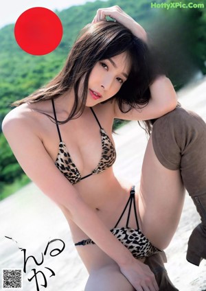 A woman in a bathing suit is posing for a magazine.