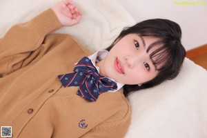 A young woman in a school uniform posing for a picture.